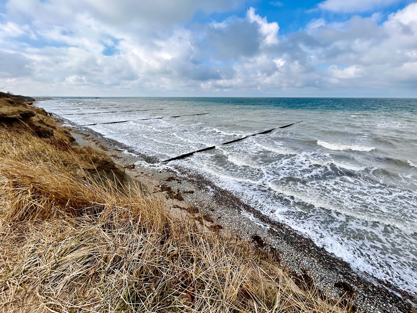 Im Vordergrund das Hohe Ufer im Hintergrund das stürmische Meer.