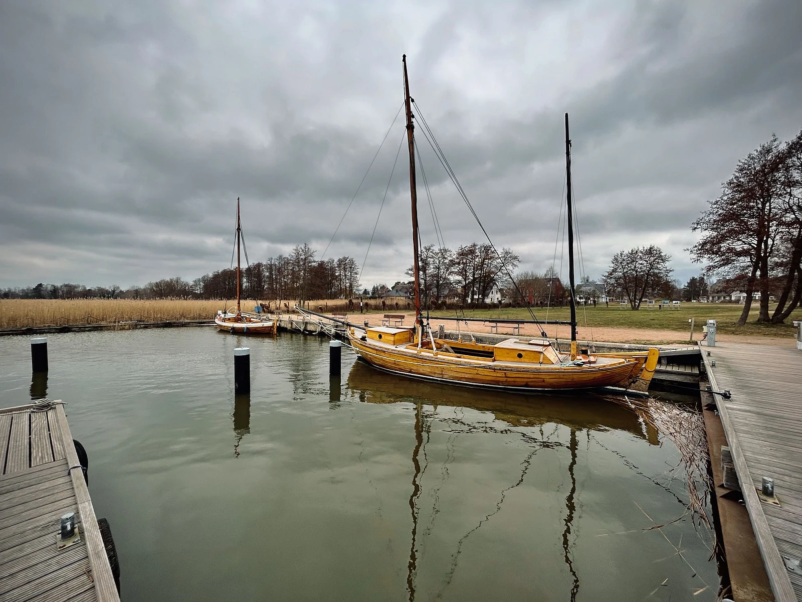 Ein Zeesboot liegt im Wecker Hafen. Der Himmel ist wolkenverhangen.