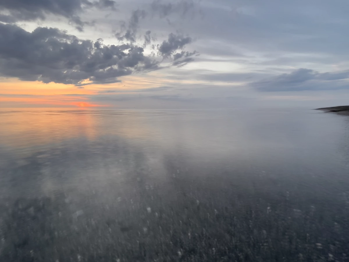 Im Mittelpunkt liegen mehrere große Steinen am Strand und in der Ostsee. Das Wasser drumherum ist durch Langzeitbelichtung verwaschen.