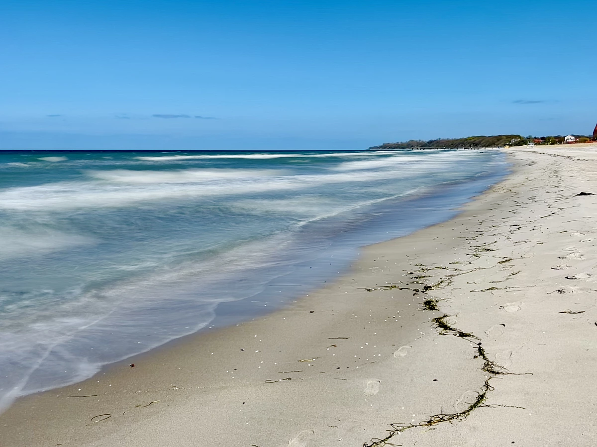 Im Mittelpunkt liegen mehrere große Steinen am Strand und in der Ostsee. Das Wasser drumherum ist durch Langzeitbelichtung verwaschen.