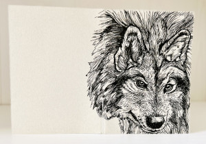 Foto eines aufgestellten und aufgeklappten Traveler's Notebooks in der Passport-Größe. Über den Rücken erstreckt sich die schwarze Zeichnung eines Wolfes auf grauem Grund.