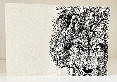 Foto eines aufgestellten und aufgeklappten Traveler's Notebooks in der Passport-Größe. Über den Rücken erstreckt sich die schwarze Zeichnung eines Wolfes auf grauem Grund.