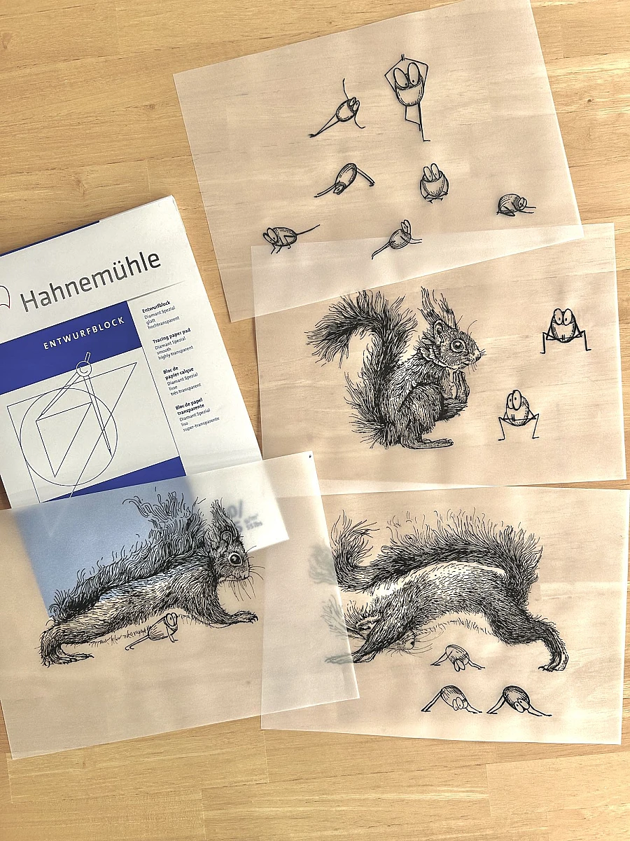 Vier Blätter Transparentpapier mit Tintezeichnungen liegen übereinander auf einem Holztisch. Links oben ein Hahnemühle Entwurfsblock.
